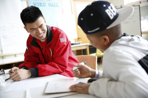 An AmeriCorps member teaching a student